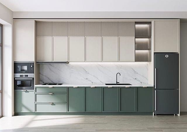 Modular kitchen with green base cabinets, a marble backsplash and fluted overhead units